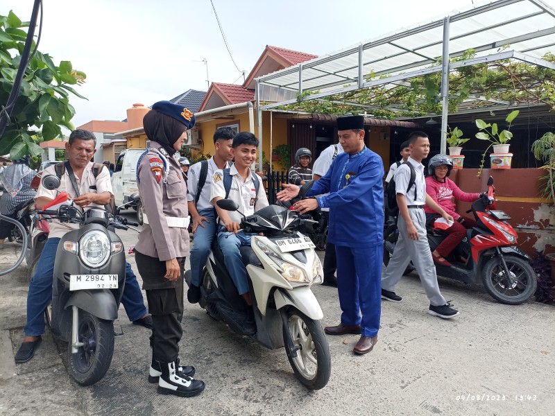 Brimob Polda Riau Bagikan Ratusan Bendera Merah Putih di SMAN 2 Pekanbaru