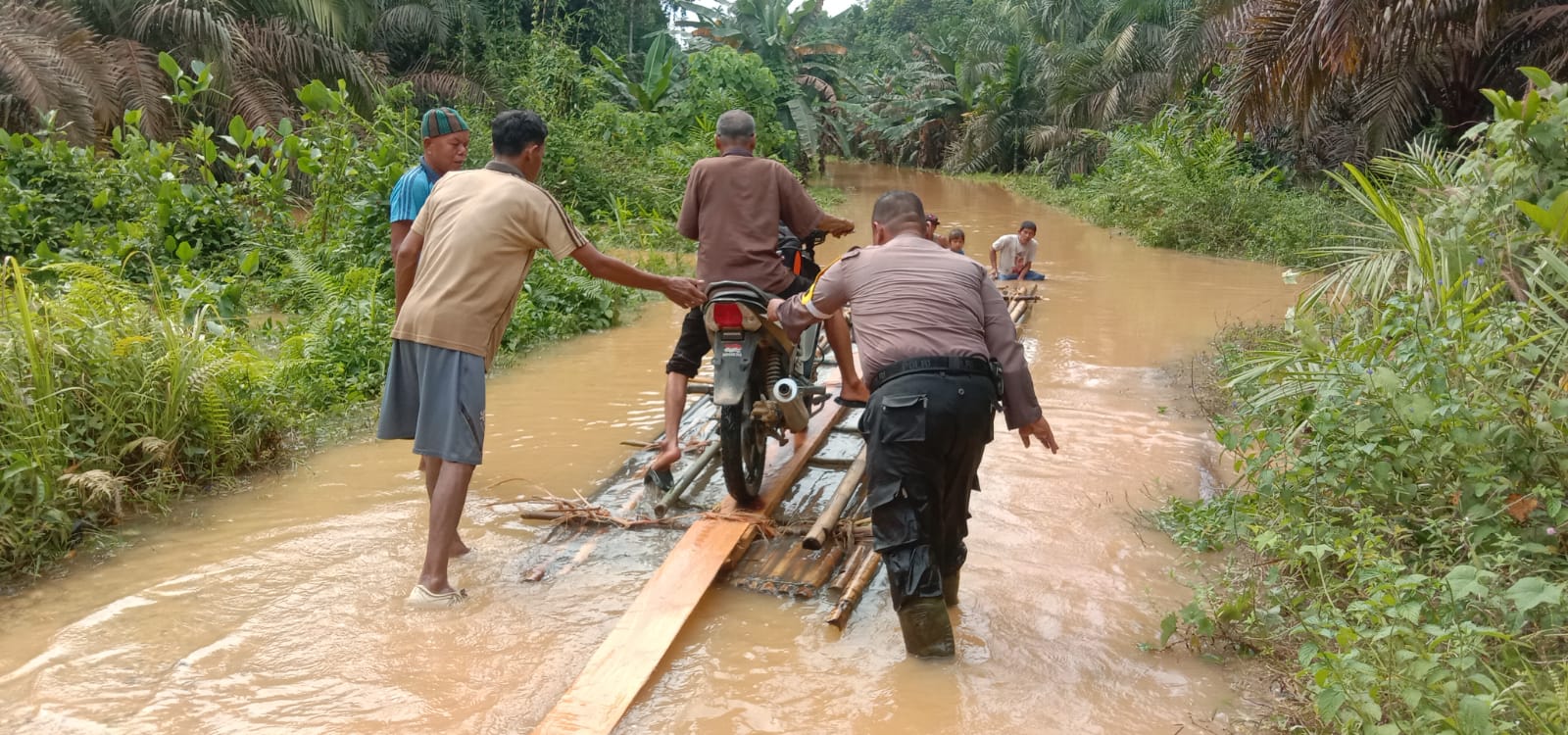 Sungai Gansal Meluap Jalan Terendam Banjir Bripka Habibi Bantu Warga Desa Siambul Lewati Banjir